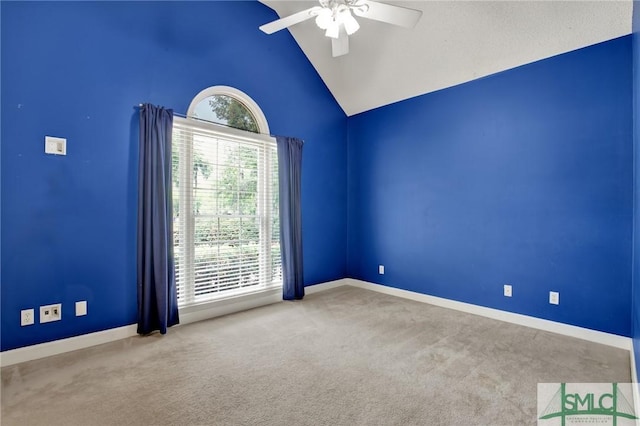 empty room featuring a ceiling fan, carpet floors, vaulted ceiling, and baseboards