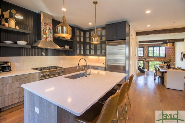 456 Port St, Savannah, GA 31401 - kitchen featuring high end appliances, wall chimney range hood, a sink, open shelves, and hardwood / wood-style flooring