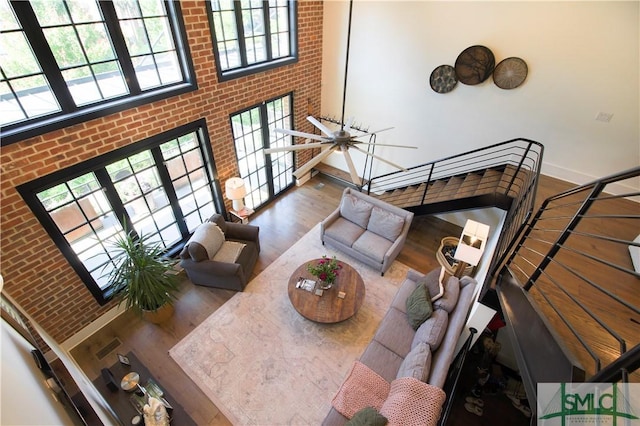 456 Port St, Savannah, GA 31401 - living area with wood finished floors, healthy amount of natural light, baseboards, and brick wall