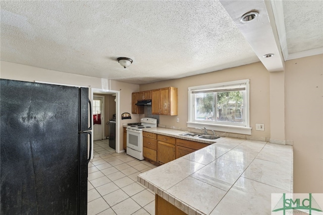 3808 Elmdale Ave, Savannah, GA 31405 - kitchen featuring white range with electric stovetop, freestanding refrigerator, a sink, a textured ceiling, and under cabinet range hood