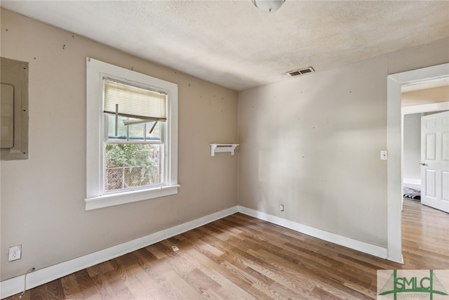 3808 Elmdale Ave, Savannah, GA 31405 - empty room featuring wood finished floors, a textured ceiling, electric panel, and baseboards