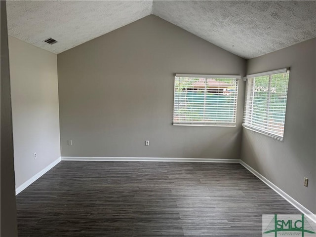 unfurnished room featuring lofted ceiling, a textured ceiling, dark wood-style flooring, and baseboards