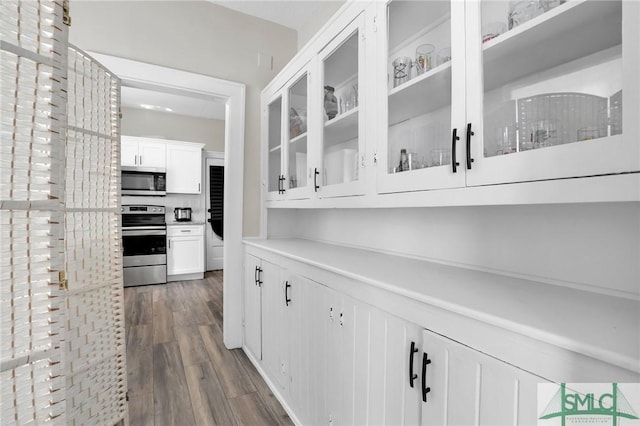 412 E 40th St E, Savannah, GA 31401 - kitchen with stainless steel appliances, dark wood finished floors, white cabinets, glass insert cabinets, and light countertops