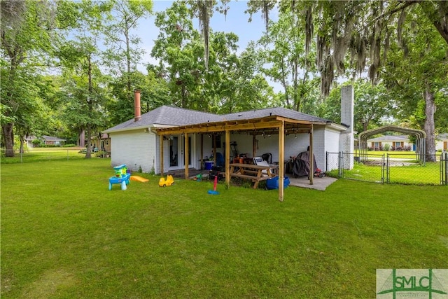 81 Quail Ln, Richmond Hill, GA 31324 - back of house featuring a chimney, a gate, a carport, and brick siding