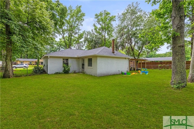 81 Quail Ln, Richmond Hill, GA 31324 - back of house featuring a chimney and brick siding