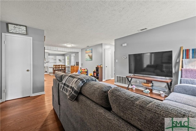 81 Quail Ln, Richmond Hill, GA 31324 - living area featuring wood finished floors, a textured ceiling, and baseboards