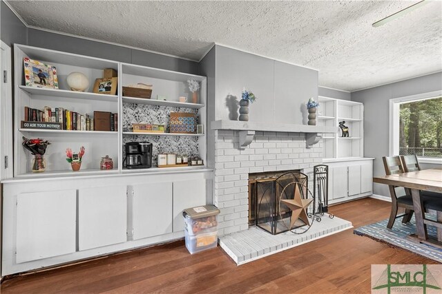 81 Quail Ln, Richmond Hill, GA 31324 - living room with wood finished floors, a textured ceiling, and a brick fireplace