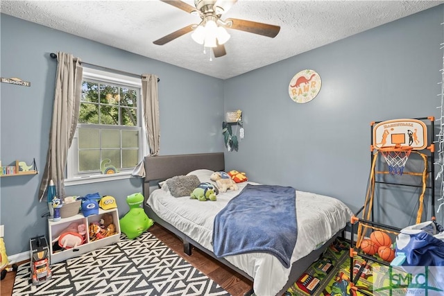 81 Quail Ln, Richmond Hill, GA 31324 - bedroom featuring a textured ceiling, a ceiling fan, wood finished floors, and baseboards