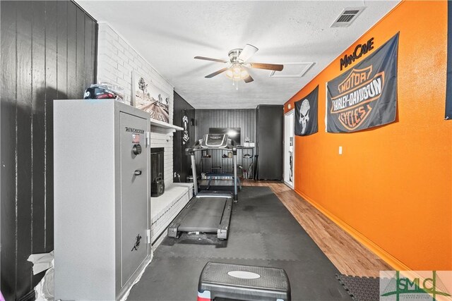 81 Quail Ln, Richmond Hill, GA 31324 - exercise area with a ceiling fan, a textured ceiling, wood walls, and baseboards