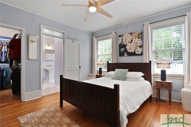 405 E 55th St, Savannah, GA 31405 - bedroom featuring a spacious closet, wood finished floors, a closet, ornamental molding, and connected bathroom