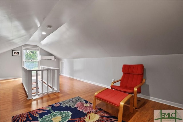 405 E 55th St, Savannah, GA 31405 - sitting room with a wall mounted AC, lofted ceiling, wood finished floors, an upstairs landing, and baseboards