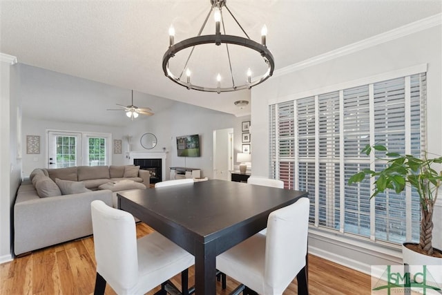 21 Carlisle Ln, Savannah, GA 31419 - dining area featuring a chandelier, a ceiling fan, a fireplace, light wood-style floors, and baseboards
