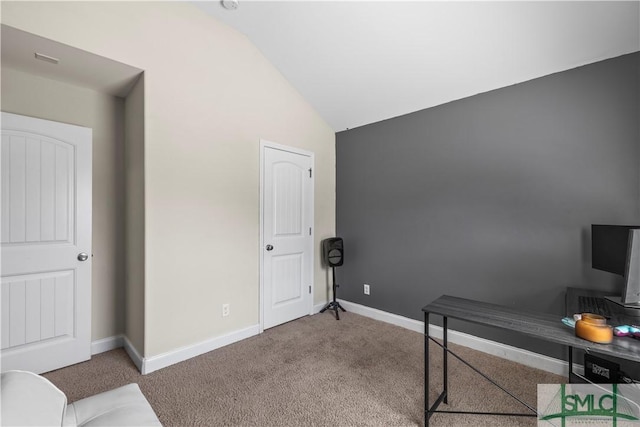 carpeted office featuring vaulted ceiling and baseboards