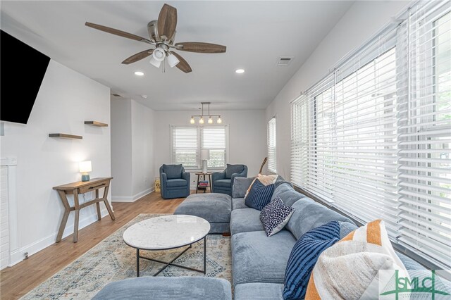 living area with light wood-type flooring, ceiling fan, baseboards, and recessed lighting