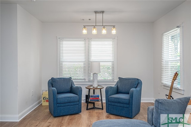 living area featuring wood finished floors, healthy amount of natural light, and baseboards