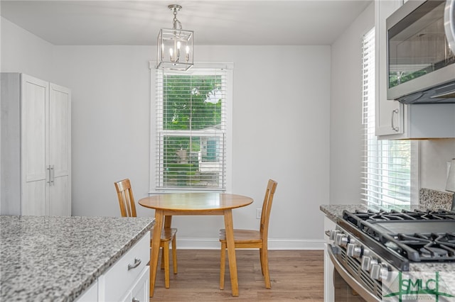 dining space with light wood-style flooring, healthy amount of natural light, and baseboards