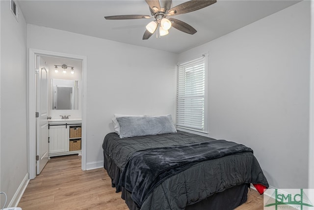 bedroom with light wood finished floors, baseboards, a sink, and ceiling fan