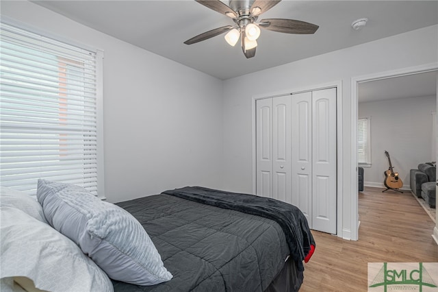 bedroom with a closet, light wood-style flooring, ceiling fan, and baseboards