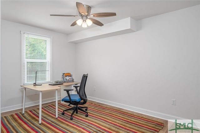 office space featuring ceiling fan and baseboards