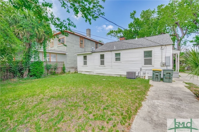rear view of property with central AC and a shingled roof