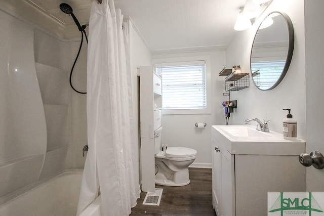 full bath with toilet, wood finished floors, vanity, and shower / bath combo