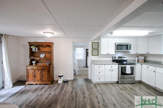 kitchen featuring stainless steel appliances, light wood finished floors, and white cabinets