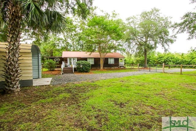 view of yard with a storage unit, an outdoor structure, and gravel driveway