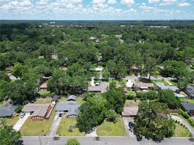 aerial overview of property's location featuring a forest and nearby suburban area