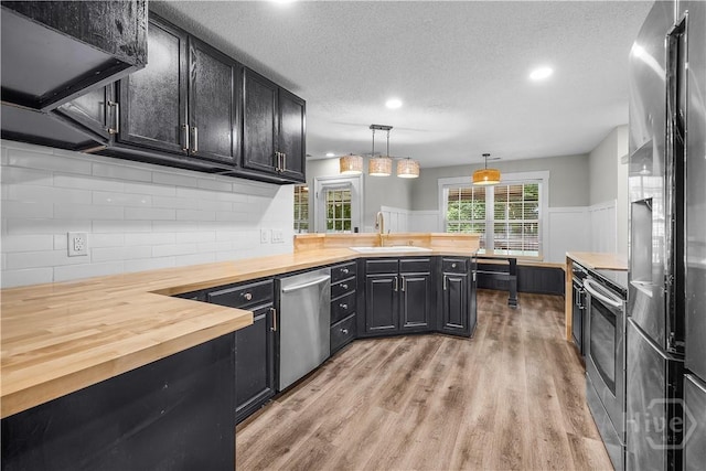 407 Middleton St, Pooler, GA 31322 - kitchen with wooden counters, a sink, appliances with stainless steel finishes, dark cabinets, and light wood-style floors