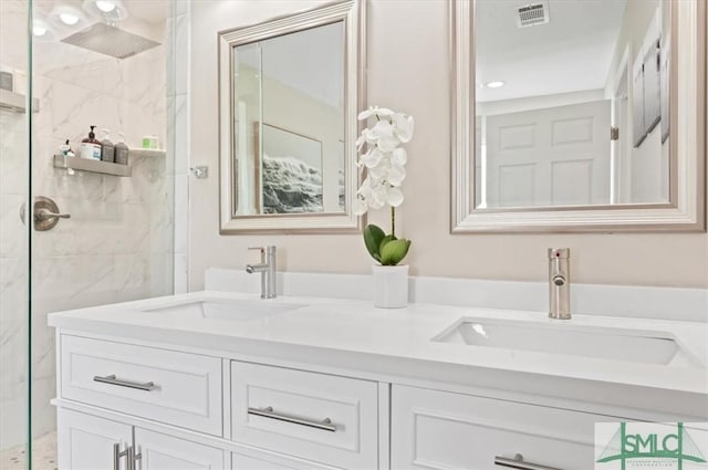 full bathroom with a marble finish shower and double vanity