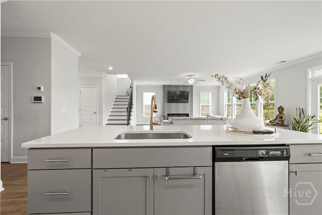 kitchen featuring dishwasher, a sink, ceiling fan, ornamental molding, and light countertops