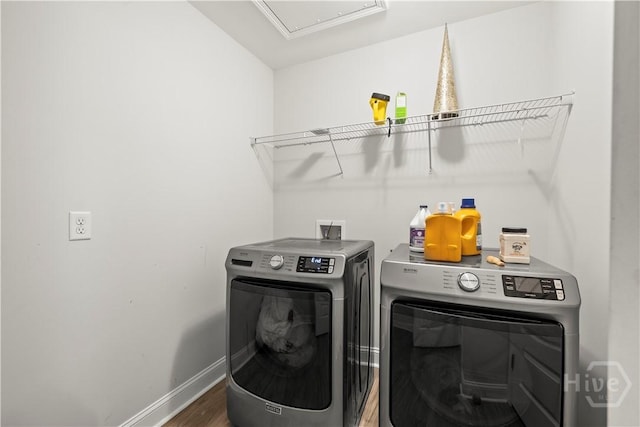 laundry area featuring washer and clothes dryer, attic access, wood finished floors, and baseboards