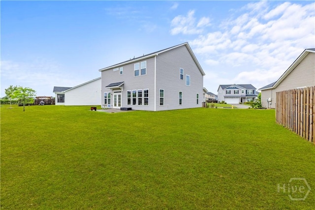 back of house featuring a yard and french doors