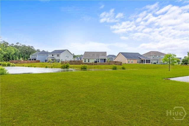 view of yard with a residential view and a water view