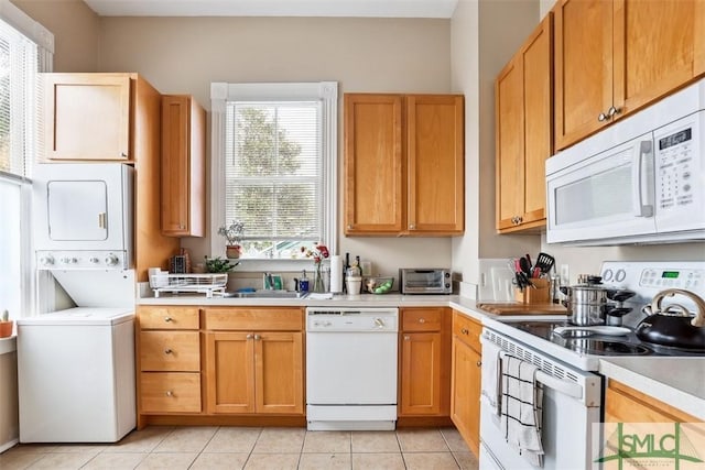 546548 E Huntingdon St, Savannah, GA 31401 - kitchen with white appliances, stacked washing machine and dryer, light countertops, and plenty of natural light