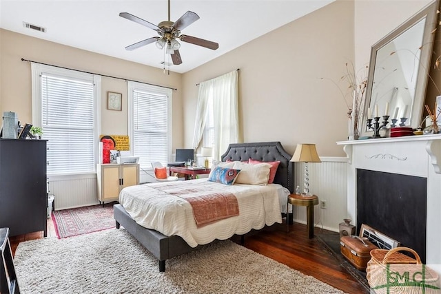 546548 E Huntingdon St, Savannah, GA 31401 - bedroom with radiator, wainscoting, wood finished floors, a fireplace, and ceiling fan