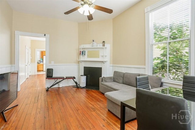 546548 E Huntingdon St, Savannah, GA 31401 - living area with wainscoting, healthy amount of natural light, a ceiling fan, hardwood / wood-style flooring, and a fireplace with flush hearth