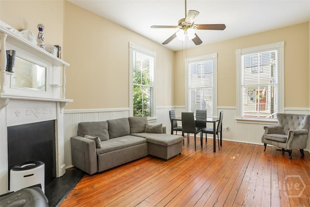 546548 E Huntingdon St, Savannah, GA 31401 - living area featuring a wainscoted wall, light wood-style floors, plenty of natural light, ceiling fan, and a fireplace with raised hearth