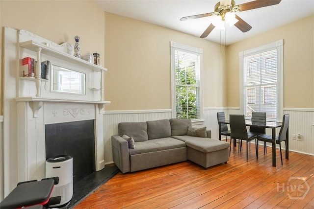 546548 E Huntingdon St, Savannah, GA 31401 - living area with a wainscoted wall, light wood-type flooring, a ceiling fan, and a fireplace with raised hearth