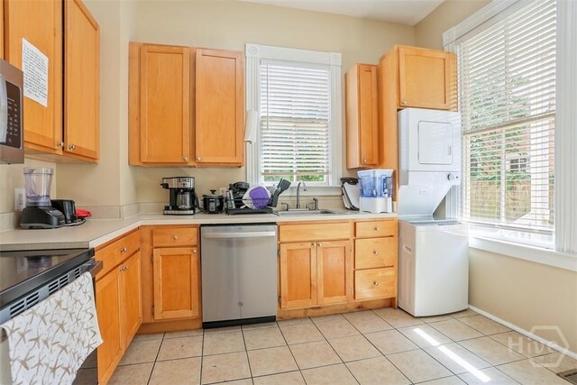 546548 E Huntingdon St, Savannah, GA 31401 - kitchen featuring appliances with stainless steel finishes, estacked washer and dryer, a sink, light countertops, and light tile patterned floors