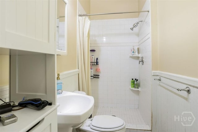 546548 E Huntingdon St, Savannah, GA 31401 - bathroom featuring a wainscoted wall, a stall shower, a sink, toilet, and a decorative wall