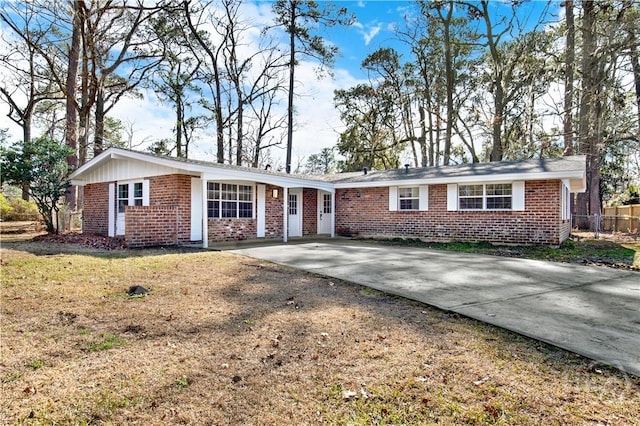 single story home featuring brick siding, driveway, and fence
