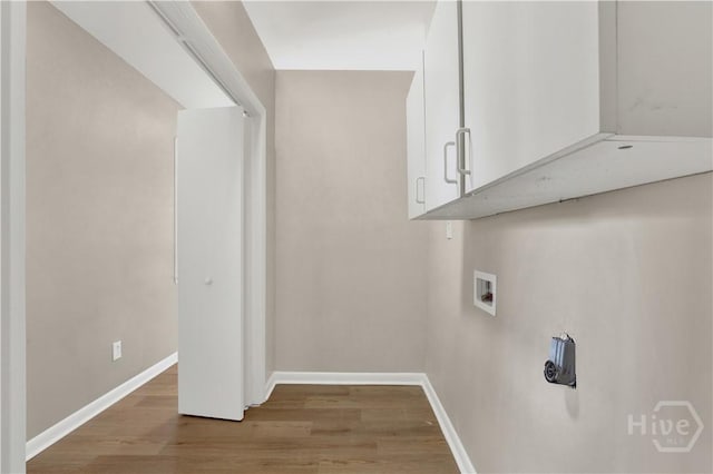 laundry room with cabinet space, light wood-style flooring, baseboards, and washer hookup