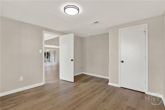 spare room featuring light wood finished floors and baseboards