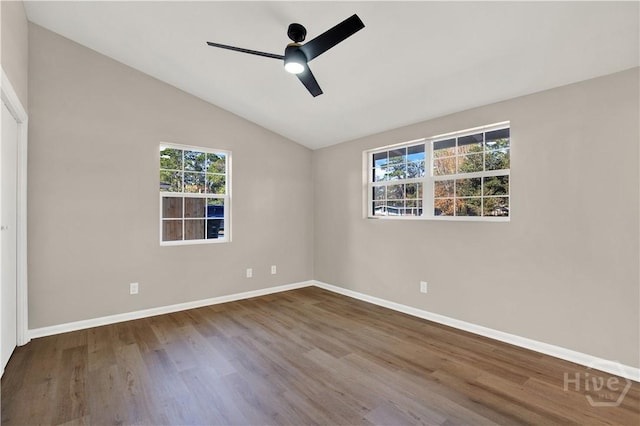 spare room featuring ceiling fan, wood finished floors, baseboards, and lofted ceiling