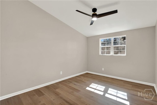 spare room with baseboards, wood finished floors, a ceiling fan, and lofted ceiling
