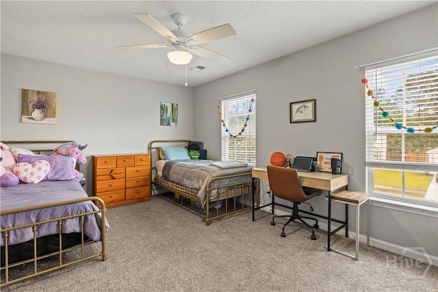 bedroom with carpet floors, multiple windows, and a desk