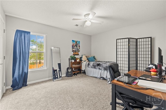 bedroom featuring carpet, a textured ceiling, a desk, ceiling fan, and baseboards