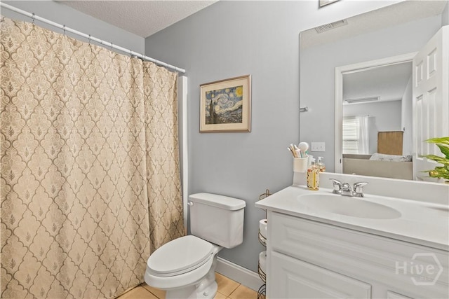 bathroom featuring tile patterned flooring, toilet, vanity, a textured ceiling, and curtained shower
