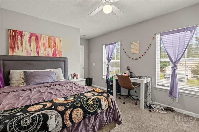 bedroom with carpet floors, baseboards, a textured ceiling, ceiling fan, and a desk